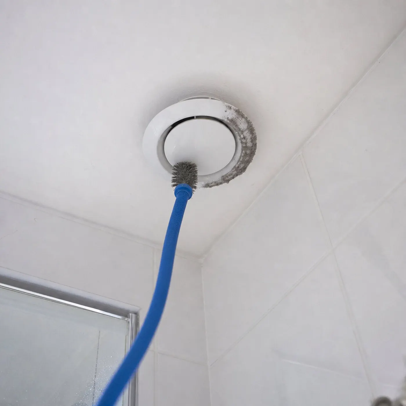 Rond plafondventiel met grijze stofrand, gereinigd met een flexibele borstel